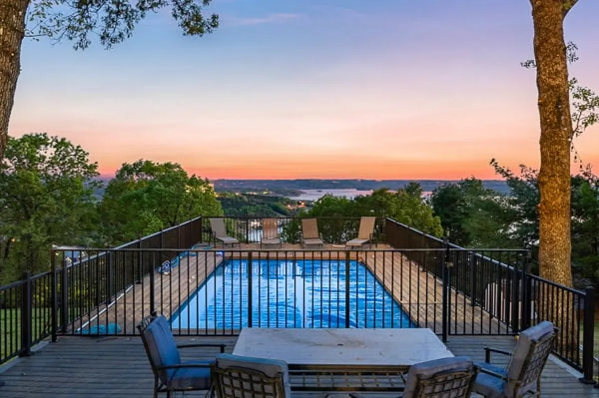 An inviting exterior scene featuring a swimming pool, comfortable outdoor seating, and a scenic distant landscape. The space exudes a sense of relaxation and is ideal for gatherings, with the serene pool and surrounding views setting a tranquil, resort-style atmosphere.